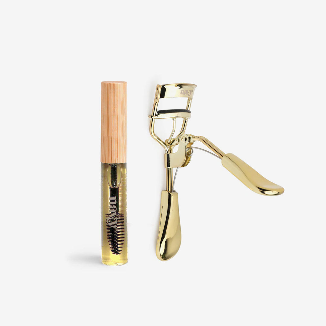 Gold eyelash curler and lash conditioning mascara wand with wooden cap on a white background