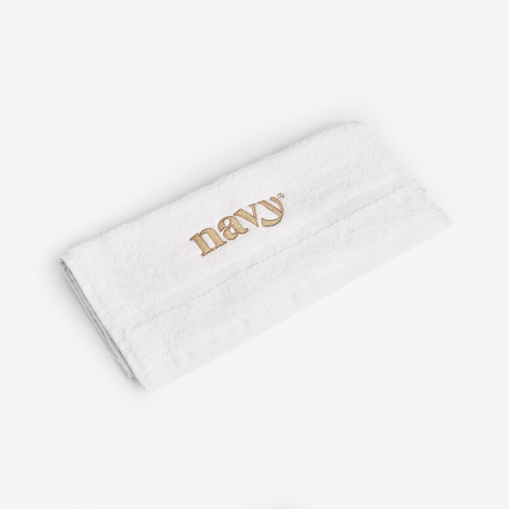 folded white towel with gold Navy logo embroidered on