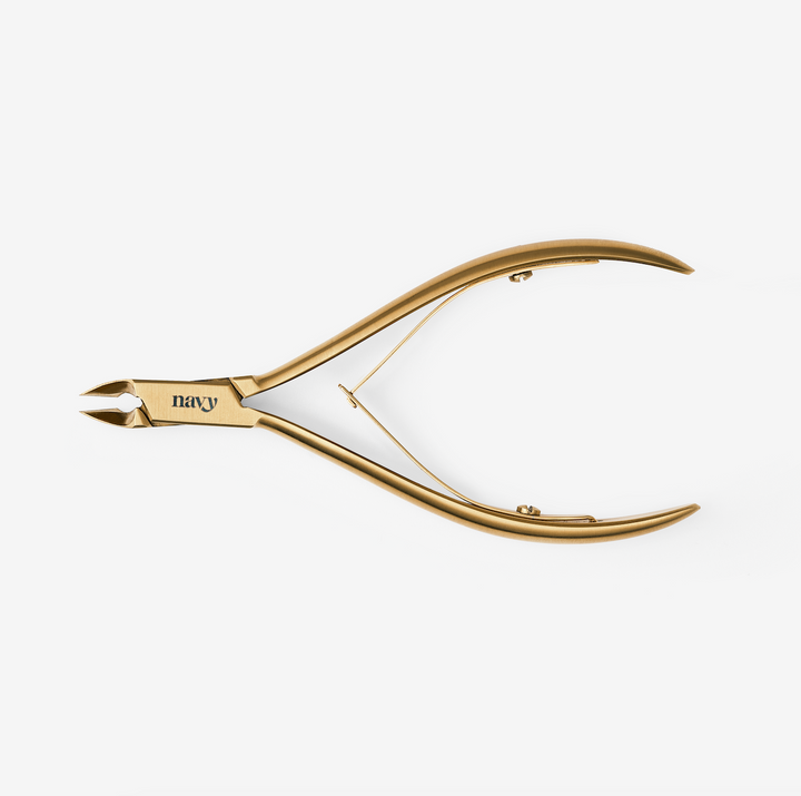 A pair of fine bladed cuticle nippers with a gold-coloured handle and stainless steel blades, featuring a protective cap.