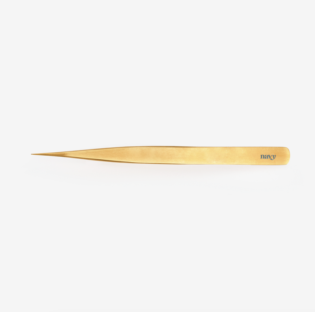 A single gold-coloured-coated tweezer with a pointed tip, against a white background.