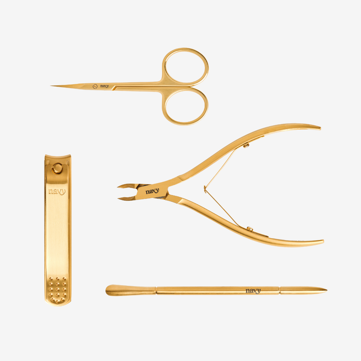 Set of gold-colored nail care tools on a white background