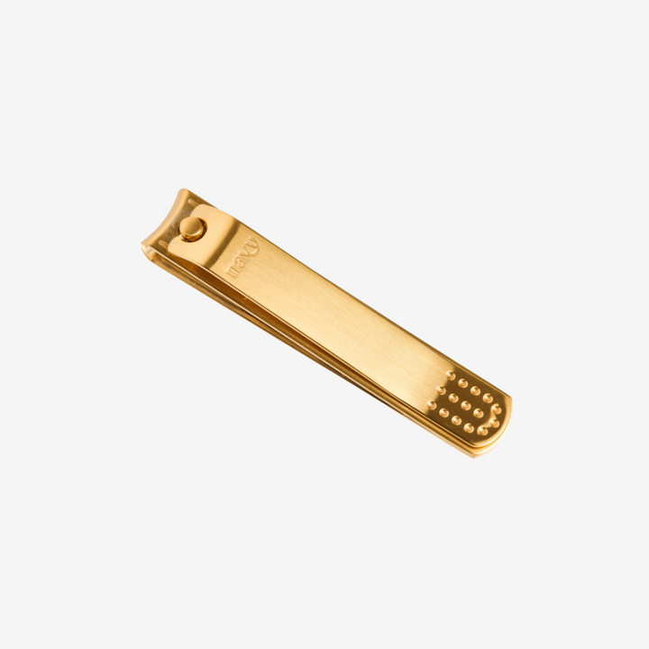 Gold-colored nail clipper on a white background