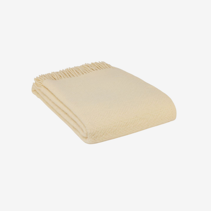 Folded beige blanket on a white background