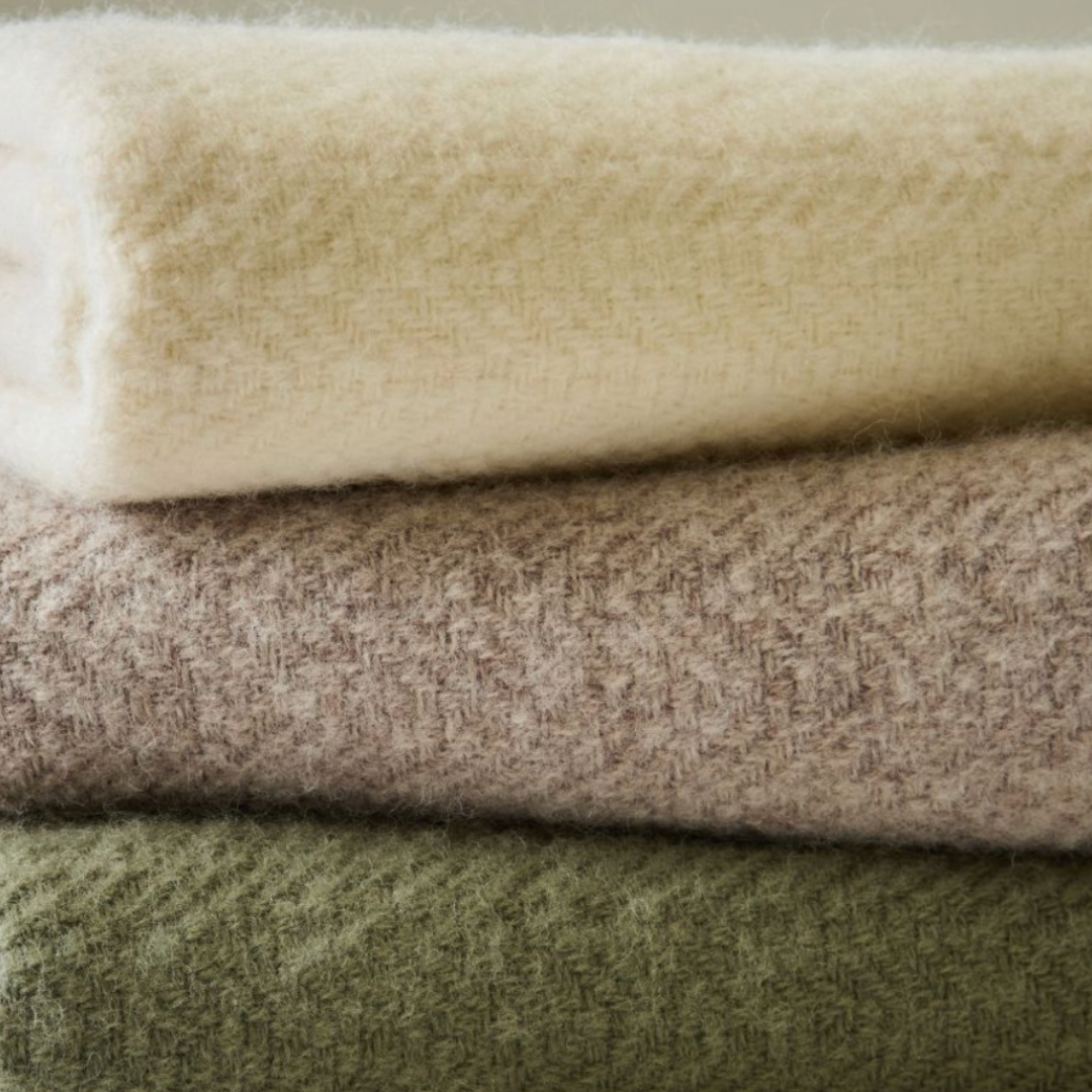 Stack of folded textured towels in beige, brown, and green.