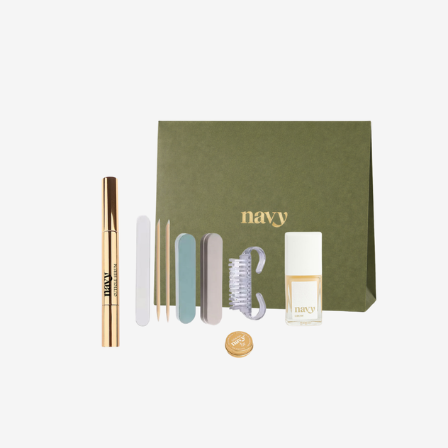 Set of beauty products including a mascara, brush, and small bottles with a green box labeled 'navy' on a white background.