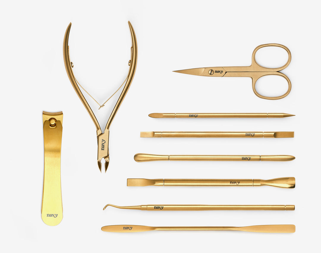 A collection of nail tools including scissors, nail clippers, and other manicure essentials, all arranged neatly on a white background.