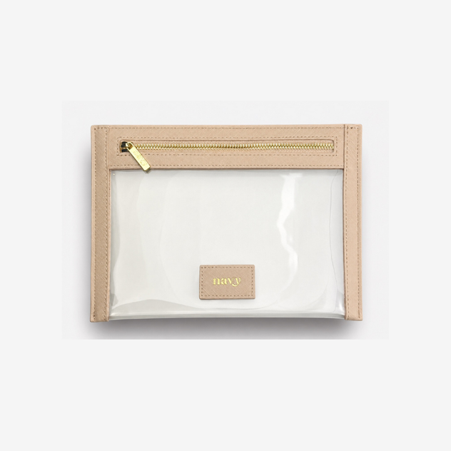 A clear plastic pouch with beige faux-leather trim and a gold zipper, featuring a small beige leather patch with the brand name 'navy' in gold lettering, set against a light gray background.