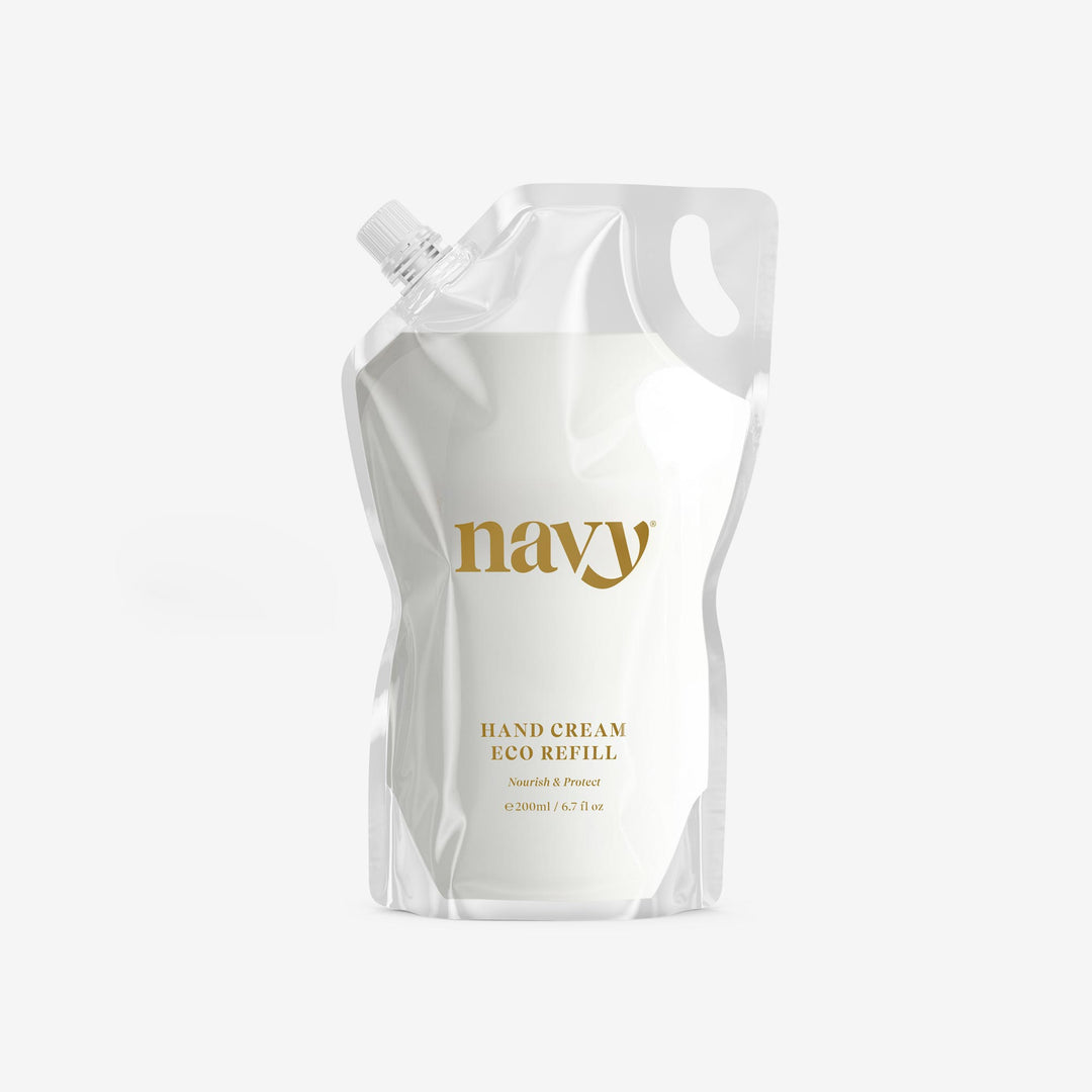 A white refilable pouch packaging labeled 'navy' for hand cream with a clear cap.