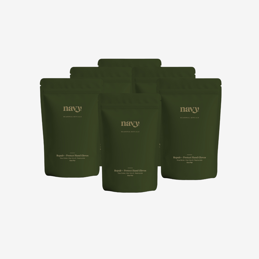 Five dark olive green stand-up pouches of Navy Botanicals tea arranged in a fan shape on a light gray background.