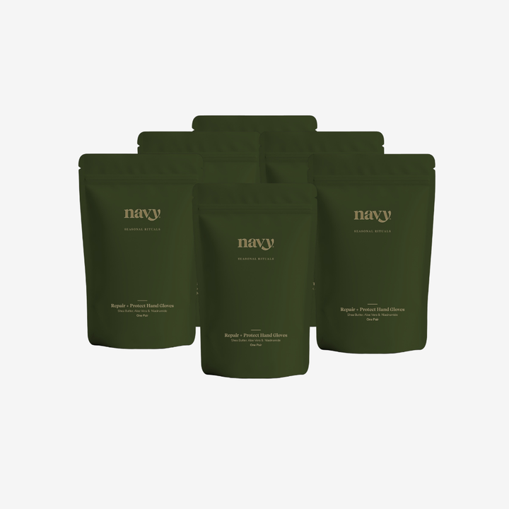 Five dark olive green stand-up pouches of Navy Botanicals tea arranged in a fan shape on a light gray background.