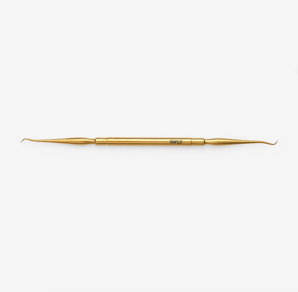 A double-ended lash lifting tool, gold in color