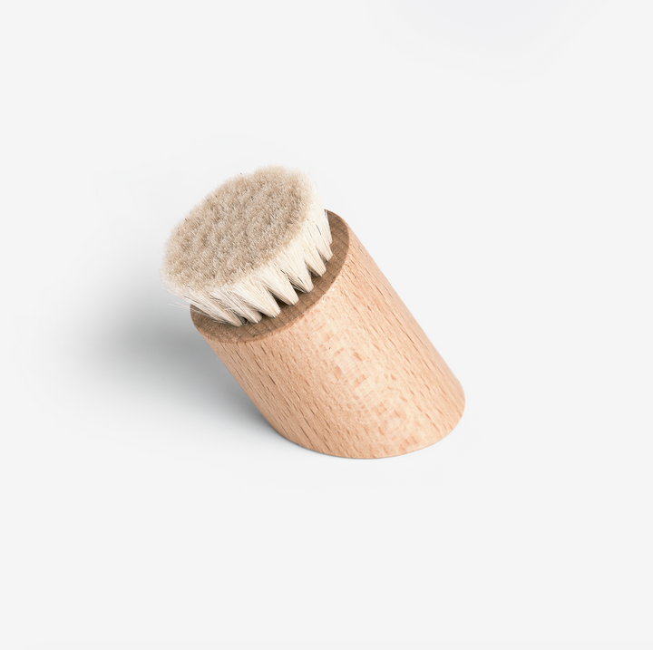 wooden dust brush sitting on its end