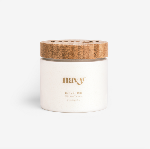 A white jar with a wooden lid labeled 'navy' containing body scrub.
