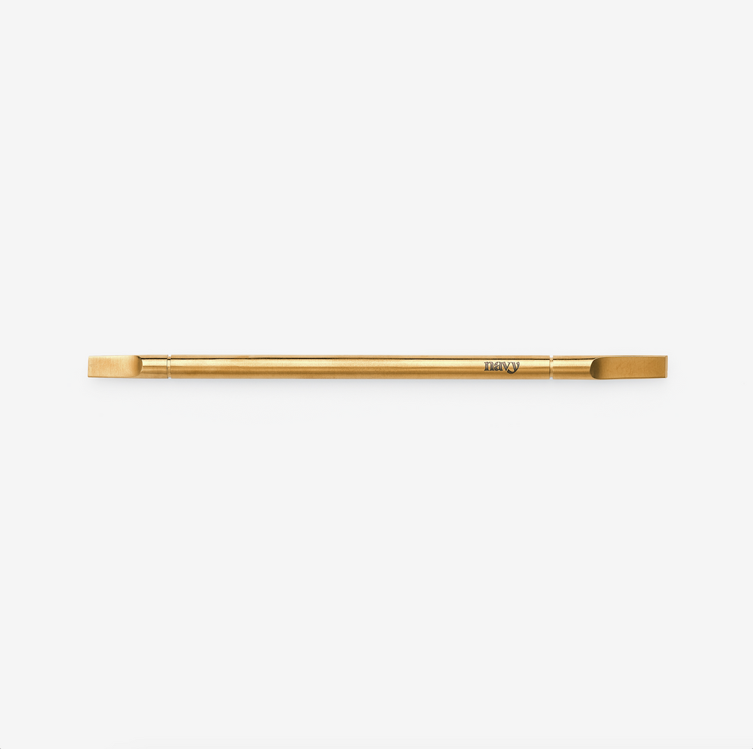 A gold-colored straight-bladed manicure multi-tool with a double-ended design, featuring a flat blade and a signature titanium finish.